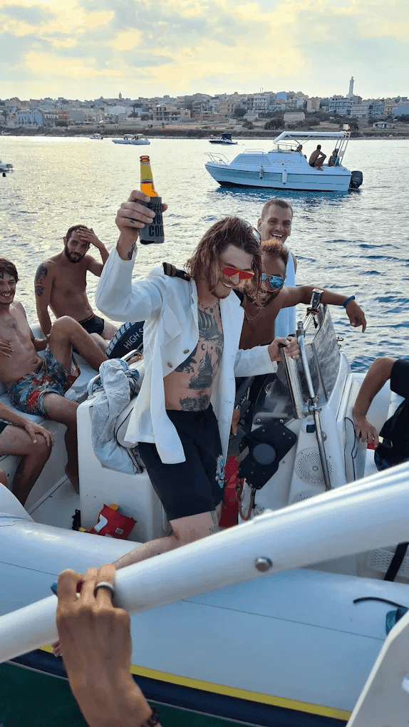 ragazzi che festeggiano al tramonto in barca